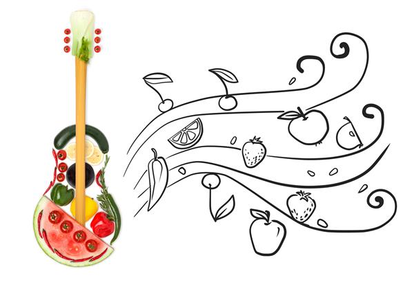 عکس خلاقانه از یک گیتار ایستاده ساخته شده از سبزیجات و میوه ها روی زمینه ای طرح دار خاکستری از نت های میوه ای روان