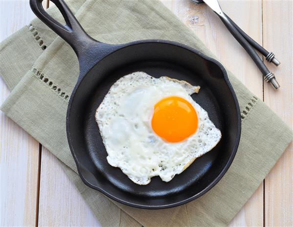 صبحانه تخم مرغ سرخ شده را در ماهیتابه آهنی