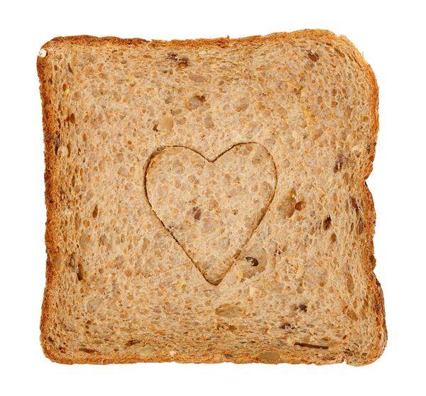 تکه نان تست نان تست گندم کامل با شکل قلب جدا شده بر روی سفید