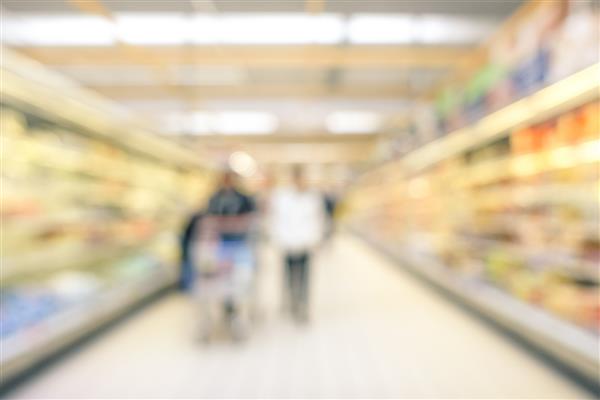 تاری تاری پس زمینه خط عمومی سوپرمارکت - مفهوم مصرف گرایی در یک دوره بحران اقتصادی - تاری خنثی چند نفر در راهرو خالی در مرکز تجاری مواد غذایی