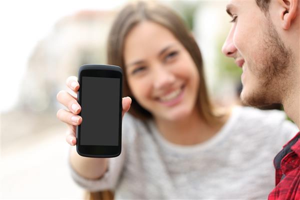 زن و شوهر خوشبختی که در فضای باز در صفحه خالی تلفن هوشمند برنامه هایی را نشان می دهند