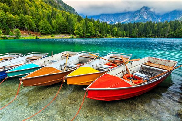 قایق های رنگارنگ در دریاچه آلپ آلاین شفاف نزدیک مرز اسلوونی و ایتالیا دریاچه فوزین ایتالیا اروپا