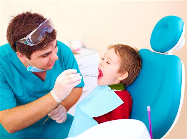 کودک کوچک متخصص ویزیت بیمار در کلینیک دندانپزشکی