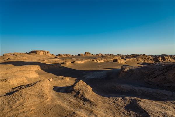 تشكیلات صخره ای در غروب خورشید در صحرای لوت ایران