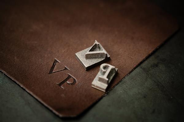 روند کار ساخت کیف پول چرمی در کارگاه چرم نماد مونوگرام جذاب با حروف وی و پی