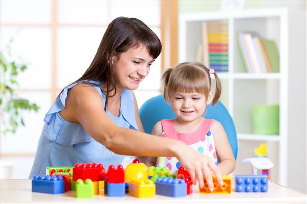 دختر بچه ای که با مادرش اسباب بازی های ساختمانی بازی می کند