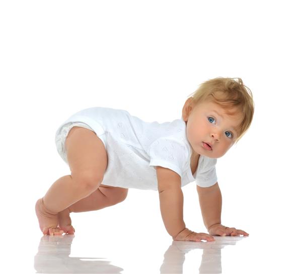 کودک شیرخوار با پوشک و خوشحال به گوشه ای نگاه می کند که سعی دارد ایستاده جدا شده روی زمینه سفید باشد