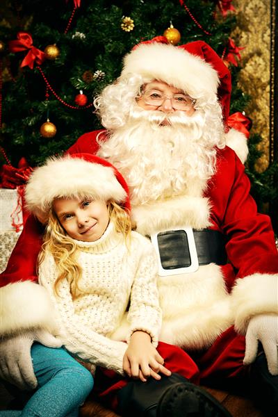 دختر کوچک که با بابانوئل نشسته