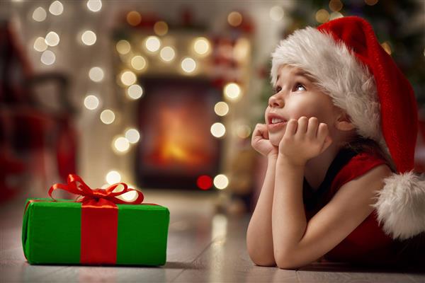 کودک خنده دار خنده دار با کلاه قرمز سانتا