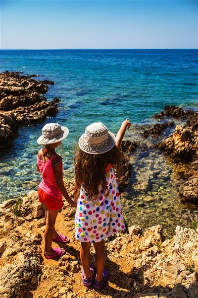 دو خواهر کوچک زیبا در سواحل صخره ای دریای آدریاتیک در کرواسی