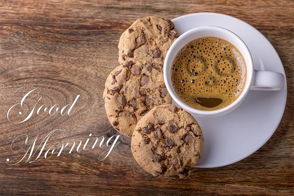 فنجان قهوه با کلوچه های شکلاتی روی چوب و صبح بخیر نوشته شده است