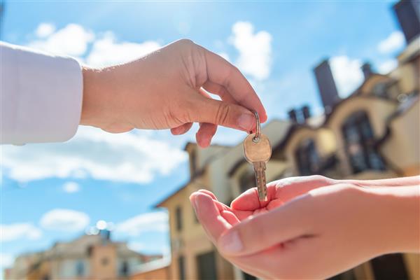 فروشنده کلید خانه را در اختیار خریدار در فضای باز قرار می دهد