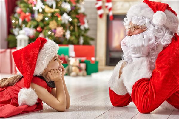 بابانوئل و دختر ناز که برای کریسمس آماده می شوند
