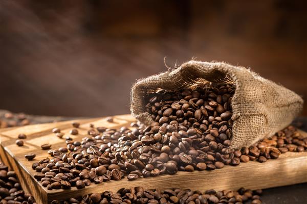 دانه های قهوه را در کیسه روی میز چوبی ریخت نور صبح