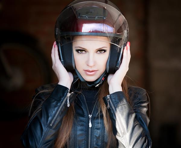 راننده زن با ژاکت چرمی مشکی کلاه ایمنی موتور سیکلت