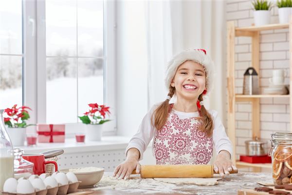 دختر کوچک بیسکویت کریسمس را می پزد