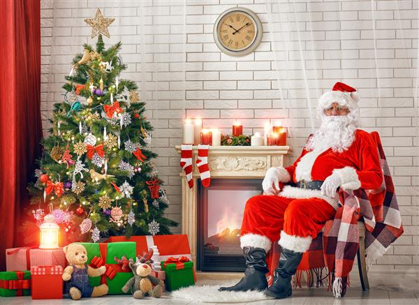 پرتره بابا نوئل که در اتاقش در خانه نزدیک درخت کریسمس نشسته است