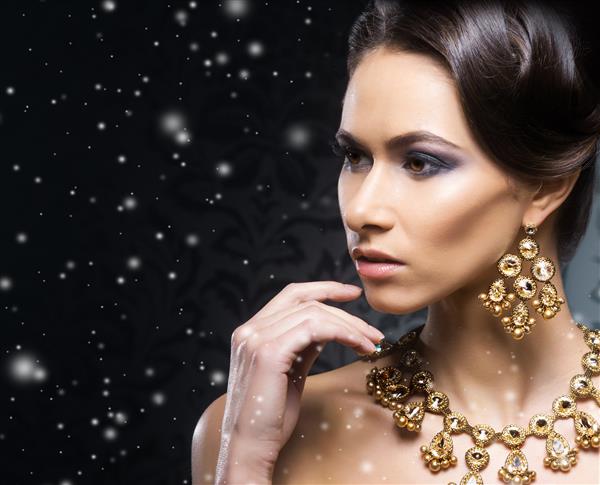 مدل زن با جواهرات پلاتین و سنگ در پس زمینه کریسمس زمستانی