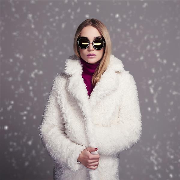 مدل زن به سبک زمستانی با خز سفید و عینک آفتابی