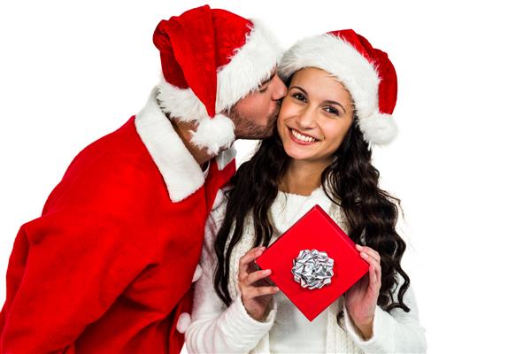 زوجی با کلاه های کریسمس روی صفحه سفید در دست دارند