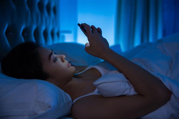 مدل زن استفاده از موبایل قبل خواب مفهوم معتاد به موبایل