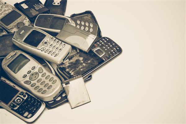 تلفن های همراه قدیمی و باتری مفهوم اتلاف الکترونیکی