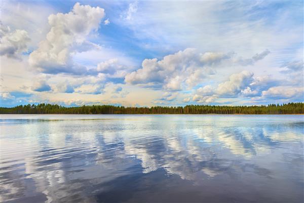 منظره ای زیبا از دریاچه و جنگل به وقت عصر درست قبل از غروب خورشید آسمان و ابرها در سطح آب منعکس شده اند فنلاند اروپا