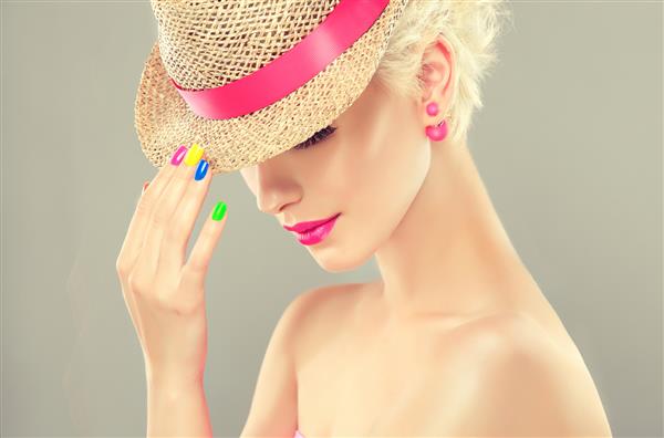 مدل زن با کلاه حصیری با ناخن های مانیکور رنگارنگ