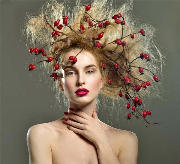 زنی زیبا با سر شاخه گل رز وحشی توت قرمز در موهای او