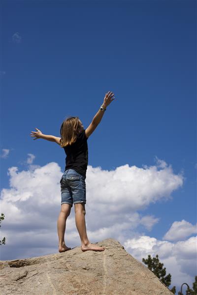 دختر جوان با بازوهای بلند شده در عبادت