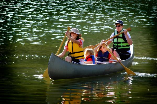 خانواده در تابستان در یک قایق رانی در دریاچه