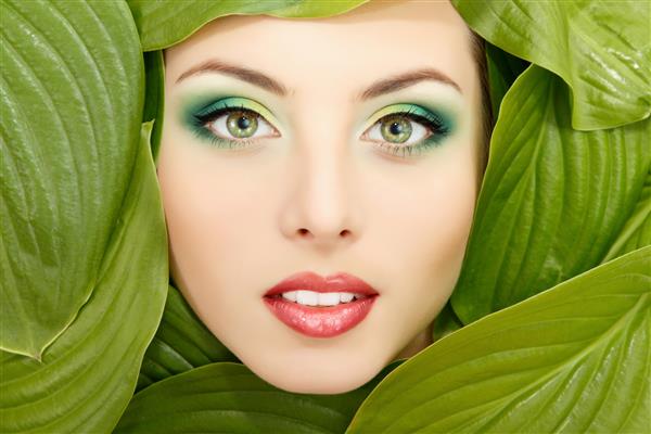 چهره مدل زن با قاب برگهای سبز