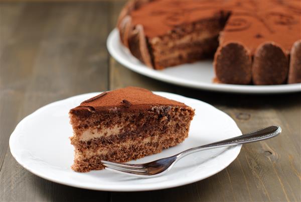 یک تکه کیک شکلاتی روی یک میز چوبی