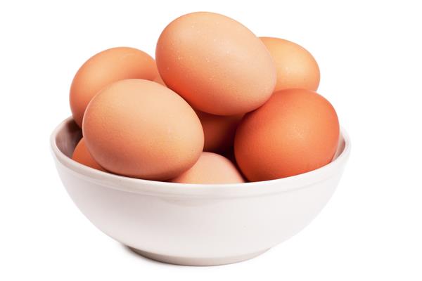 تخم مرغ های قهوه ای در یک کاسه روی زمینه سفید