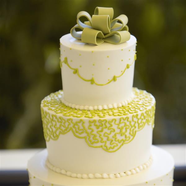 نمای نزدیک از کیک عروسی با تزیین دقیق در هنگام پذیرایی