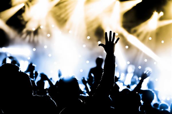 تشویق جمعیت و دستان بلند شده در یک کنسرت موسیقی زنده