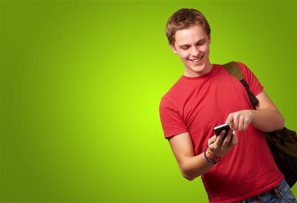 پرتره از یک مرد جوان و تلفن همراه در پس زمینه سبز
