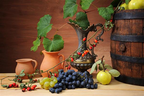 بشکه چوبی برای شراب پارچ سرامیک و میوه روی میز