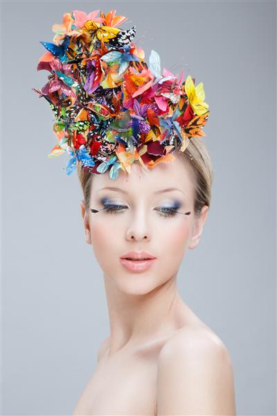 تصویر نزدیک از یک دختر زیبا با یک پروانه از گلها و آرایش خلاقانه جدا شده