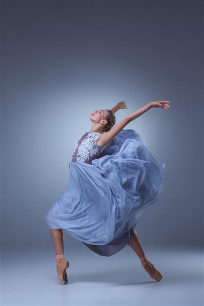 رقصنده بالرین زیبا با لباس آبی بلند در زمینه آبی