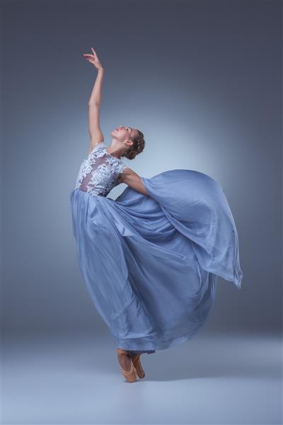 رقصنده بالرین زیبا با لباس آبی بلند در زمینه آبی
