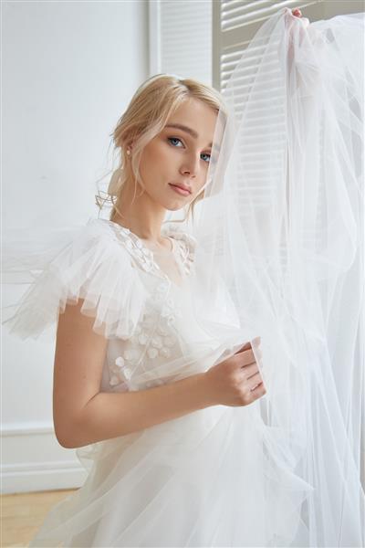لباس عروس سفید لوکس روی بدن دختر مجموعه جدید لباس عروس عروس صبح زنی که قبل از مراسم عروسی منتظر داماد است عروس جوان با لباس بلند