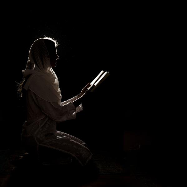 تصویر زن در حال خواندن قرآن