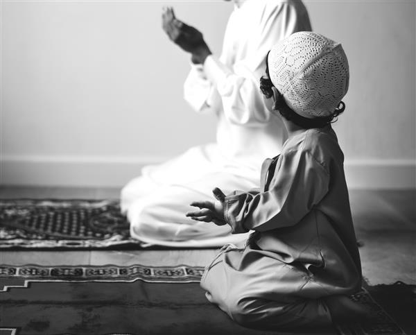 پسر مسلمان در حال یادگیری نحوه دعا برای خداست