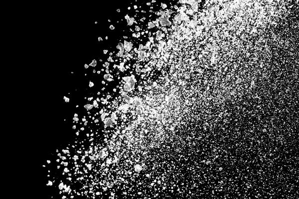 انفجار پودر سفید جدا شده در زمینه سیاه برای منابع گرافیکی