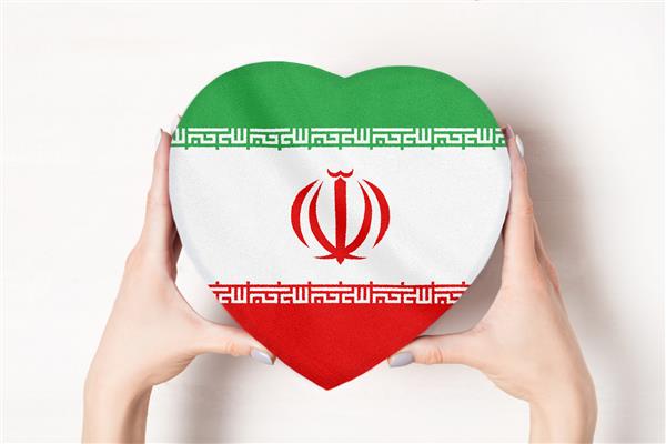 پرچم ایران بر روی جعبه ای به شکل قلب در دستان یک زن