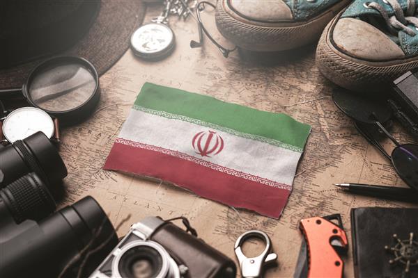 پرچم ایران بین لوازم جانبی مسافر بر روی نقشه قدیمی مفهوم مقصد گردشگری