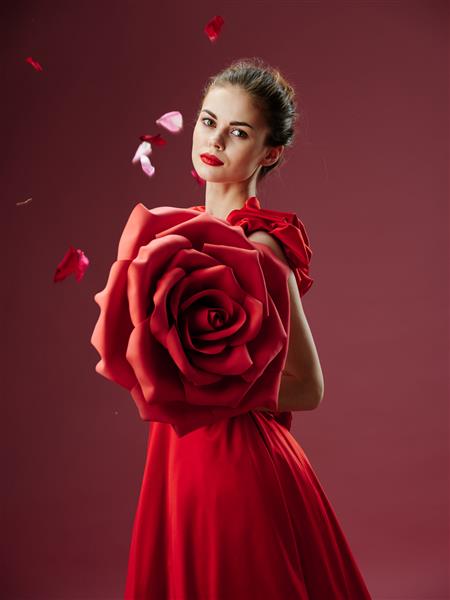زن جوان زیبا با لباس مجلل با گل رز گلبرگ رز تصویر شیک رژ لب قرمز