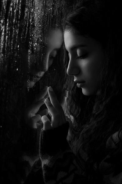 مدل زن نزدیک پنجره با قطرات باران