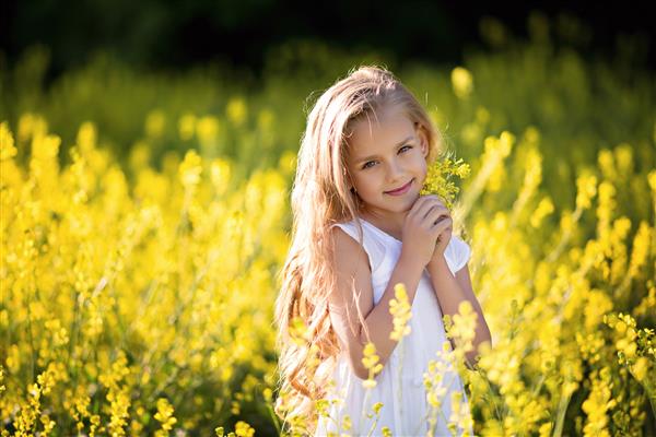 پرتره یک دختر کوچک شاد در طبیعت در تابستان